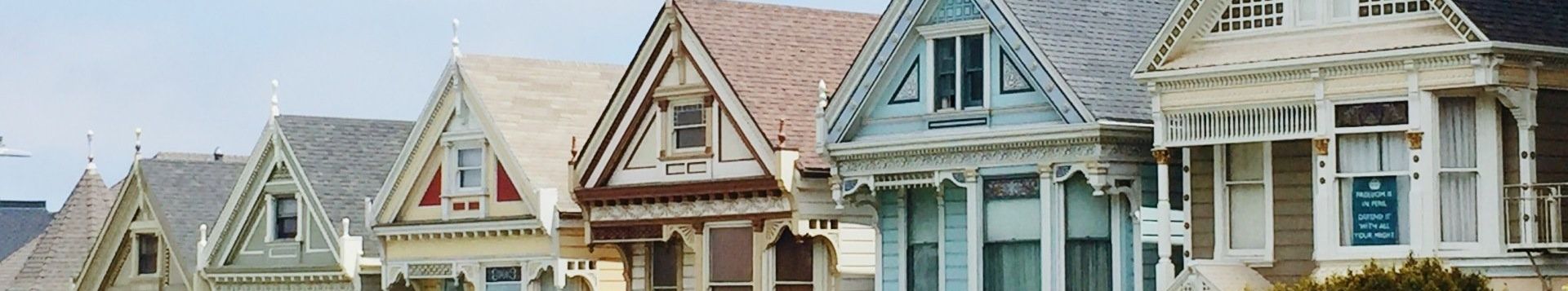 A row of houses are lined up in a row on a sunny day.