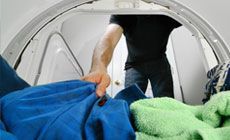 Man taking clothes out of a dryer