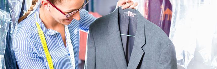 Lady holding jacket on wire coat hanger