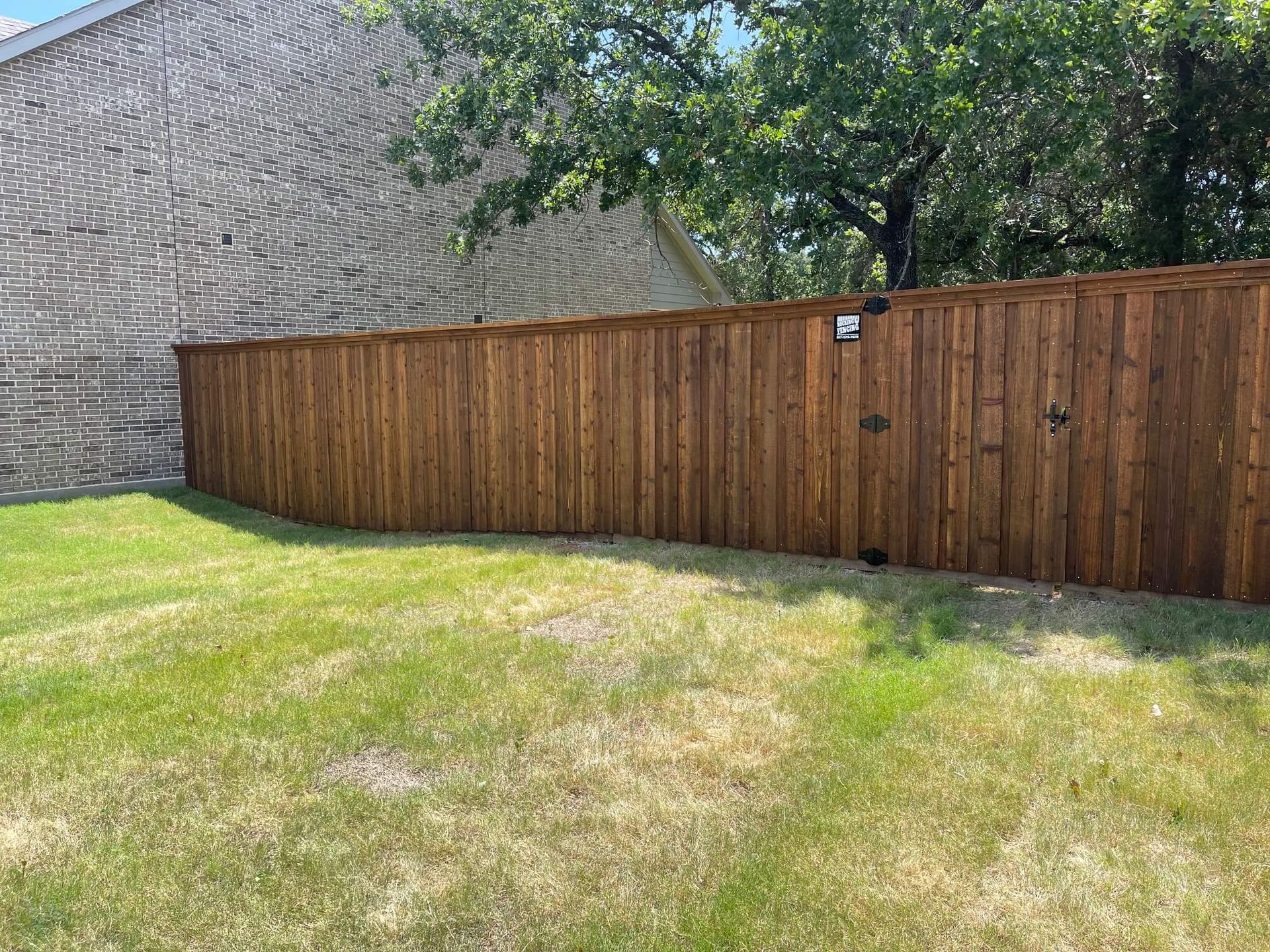 A Wooden Fence Is in The Middle of A Lush Green Yard