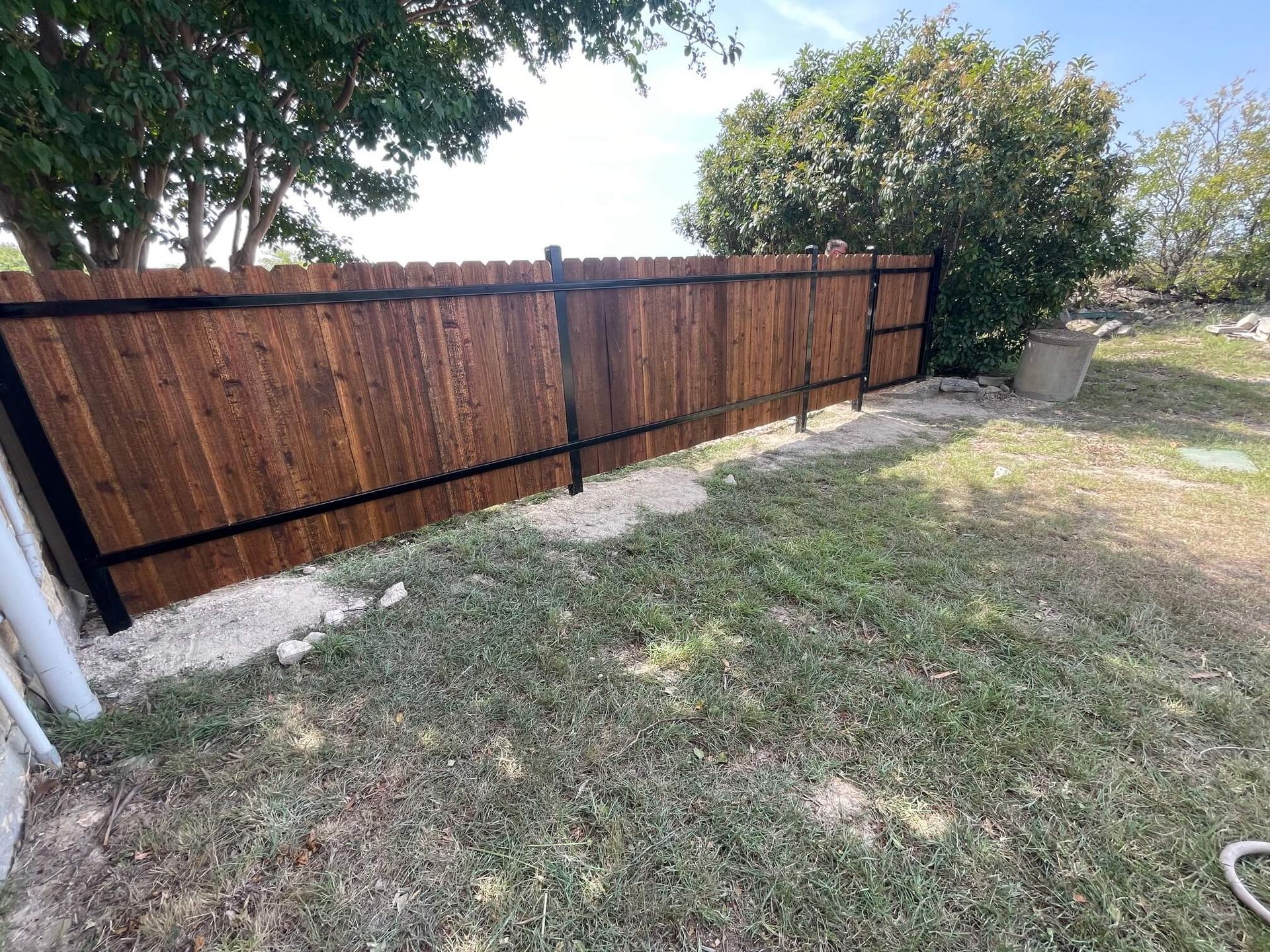 A Wooden Fence Is in The Backyard of A House