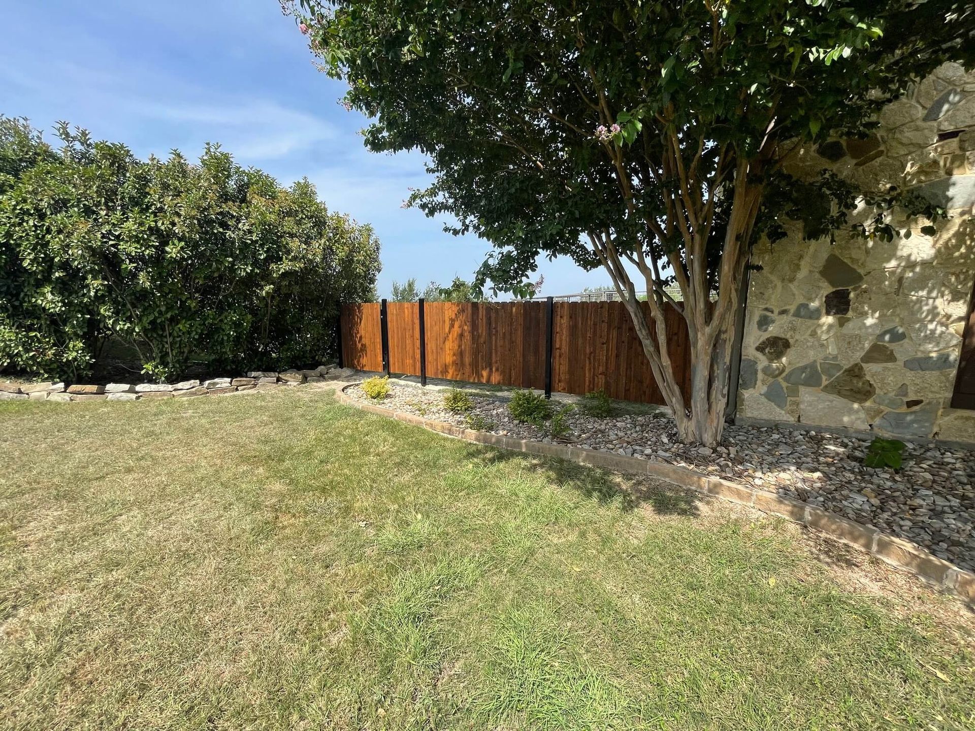 A Wooden Fence Surrounds a Large Lush Green Field