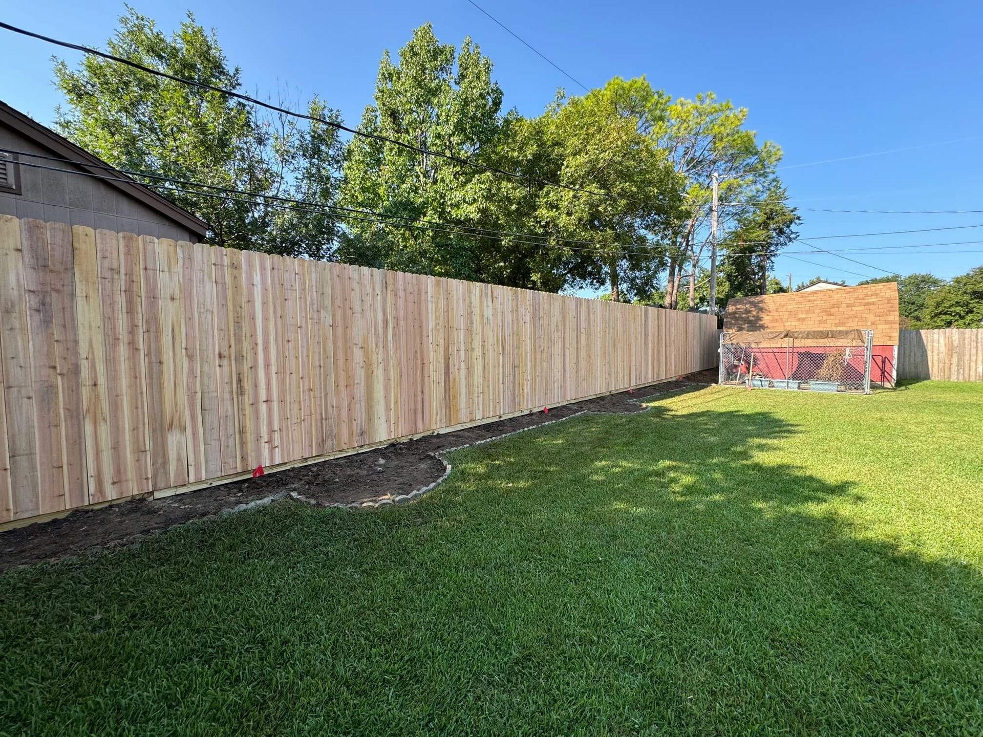 A Wooden Fence Surrounds a Lush Green Yard