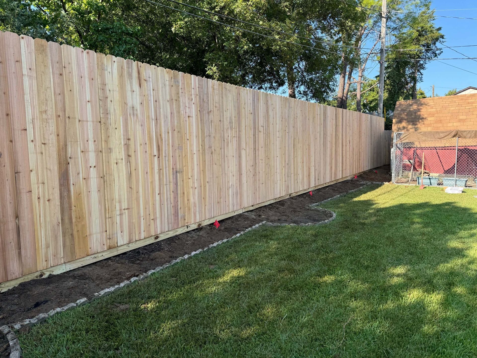 A Wooden Fence Is Sitting in The Middle of A Lush Green Yard