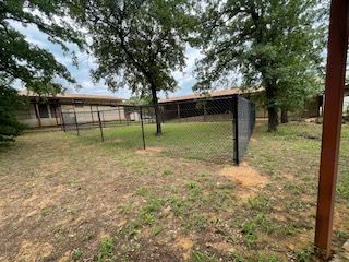 Fence in Yard with Trees and A House in The Background