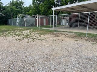 Chain Link Fence Surrounds a Gravel Lot in Front of A House