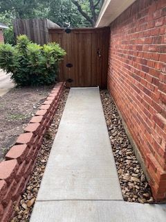 Brick Wall with A Concrete Walkway Leading to A Wooden Gate