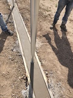 Laying Concrete on The Ground Next to A Metal Pole