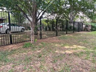 White Car Parked Behind a Wrought Iron Fence