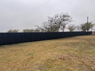 Long Black Fence in The Middle of A Grassy Field