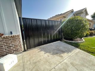 Black Fence Is Sitting in Front of A Brick House