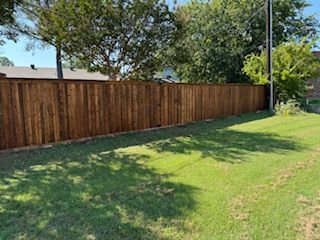 Wooden Fence Surrounds a Lush Green Lawn in A Backyard