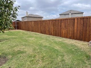 Wooden Fence Surrounds a Lush Green Lawn in A Backyard