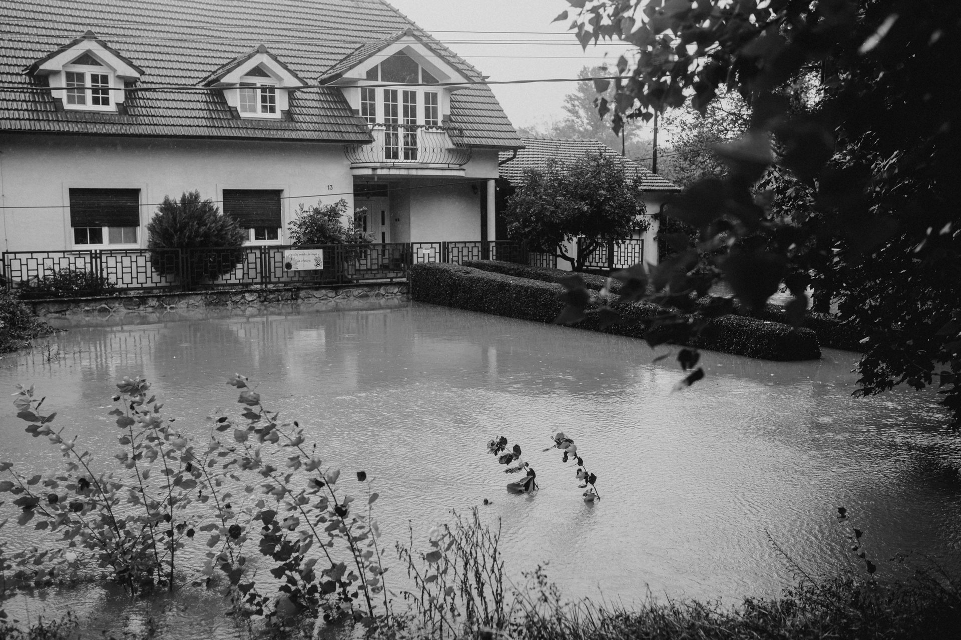 Flooded yard in front of a house, possibly due to heavy rain.