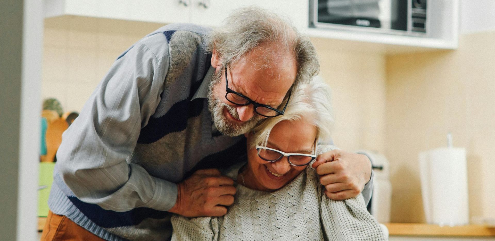 A family is walking through a grassy field holding hands.