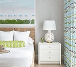 Bedroom with white bedding, wooden headboard, white nightstand, and art.
