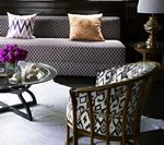 Living room with patterned sofa and chair, coffee table, and lamp.