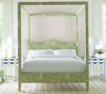 Green patterned canopy bed in a bright bedroom.
