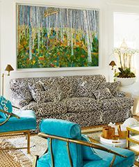 Living room with leopard print sofa, large artwork, turquoise chairs, and gold accents.