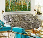 Living room with patterned sofa, teal chairs, and landscape artwork.