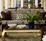 Living room with patterned sofa, coffee table, and plants.