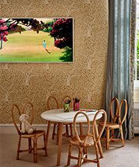 A child's room with a round table, chairs, and a painting on the wall.