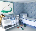 Blue and white nursery with a crib, twin bed, alligator art, and giraffe.
