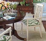 Wooden dining room table and chairs with green patterned cushions.