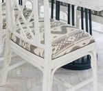 White chair with patterned seat cushion, partial view.