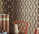 Books, chair, and basket in front of a patterned brown and tan wall.
