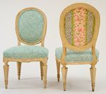 Two light wood chairs with oval backs and patterned upholstery.