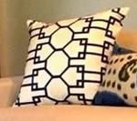 White pillow with a black geometric design; another pillow is partially visible.