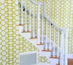 White staircase with green and white patterned wallpaper.