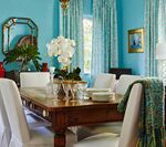 Dining room with a wooden table, white chairs, and turquoise walls.