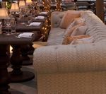 Cozy restaurant interior with a tufted sofa, round tables, and place settings.