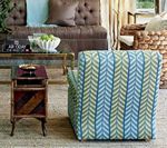 Blue and green patterned armchair in a living room, next to a wooden side table.