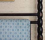 Dark wooden bed frame with a patterned blue and white blanket.