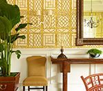 Yellow patterned wallpaper, console table with decor, chair, and potted plant.