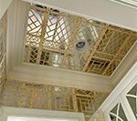 Ornate, latticework ceiling design with recessed lighting, bordered by crown molding.