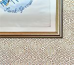 Framed artwork over a geometric wallpaper background. 