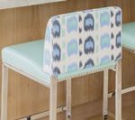 Bar stool with light blue cushion and patterned backrest, in a light wood setting.