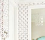 Wallpapered room with floral pattern, white door, and view into another room.