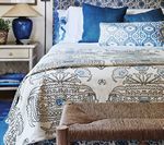 Bedroom with blue and white patterned bedding and accents.
