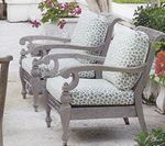 Two gray wooden outdoor armchairs with patterned cushions.