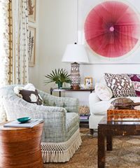 Living room with teal armchair, white sofa, and large pink art.