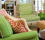 Living room with green sofa, chair, and patterned pillows.