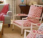 Living room with patterned armchairs, blue sofa, and textured rug.