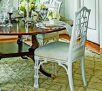 White dining chair with decorative back at a table.
