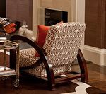 Armchair with patterned fabric and wooden frame, next to a silver bar cart.