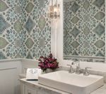 Bathroom with floral wallpaper, white sink, and silver faucet. Purple flowers on the countertop.